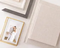 close up photo of album and frame products with couple looking at eachother