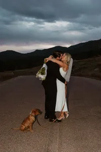 Couple eloping with mountains in the background and a golden retriever puppy at Cheyenne Mountain State Park