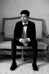 Groom sitting in black tuxedo waiting for his bride on wedding morning at Sunstone Winery.