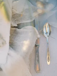 Close-up of vintage spoon and linen fabric in editorial wedding styling