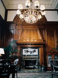 Elegant interior of the historic Nines Hotel in Portland with wood paneling, marble details, and a grand chandelier where the couple prepared before their winery wedding.