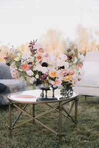 Lush floral arrangement with garden roses and seasonal blooms decorating the reception lounge area at a romantic Oregon winery wedding.