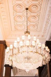 Ornate chandelier and decorative ceiling architecture inside the historic Nines Hotel in Portland where the couple prepared before their Lake Oswego Oregon winery wedding.