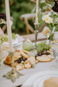 Wedding table detail with bread, fruit, and cheese arranged for outdoor reception