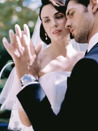 Close embrace between bride and groom, her veil catching the breeze against his tuxedo, a candid moment from a Santa Barbara wedding editorial by Yuliya Supin Design