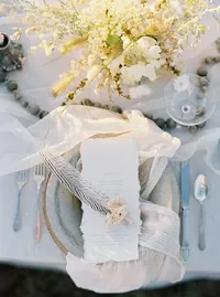 Wedding table with layered linens, florals, and soft neutral palette