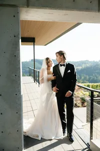 Bride and groom sharing their first look on an elevated terrace overlooking the vineyard.