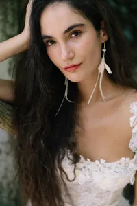 Close portrait of model wearing feather earrings and bridal styling captured for Lake Como editorial