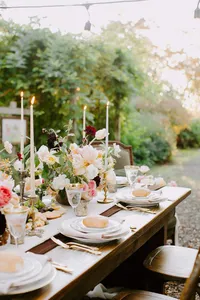 Garden wedding table design with floral centerpiece, candles, and layered textures