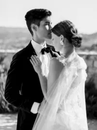 Groom kissing bride’s forehead during intimate moment at Sunstone Winery wedding.