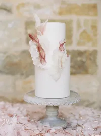 Wedding cake decorated with delicate sugar flowers inspired by bride’s gown details.