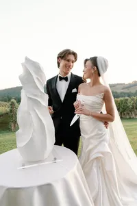 Modern organic wedding cake designed to mimic the bride’s dress texture as the couple prepares to cut the cake at Lucid Wild Vineyard.
