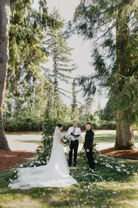 Outdoor garden ceremony with white and green floral arch at private estate wedding in Vancouver, Washington.