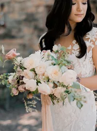 Bride portrait holding lush bouquet of garden roses and romantic blooms during an elegant winery wedding in Lake Oswego Oregon.