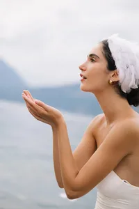 Model blowing kiss toward lake creating soft poetic moment during Lake Como editorial shoot