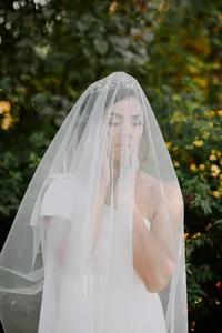 Bride portrait through veil with bouquet in outdoor garden wedding setting