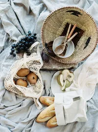 Editorial picnic styling with bread, grapes, and natural textures for wedding design