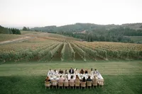 Luxury reception table extending toward rolling Oregon hills at sunset.