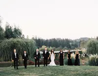 Bridal party walking together through the garden toward the reception celebration at a Lake Oswego Oregon winery wedding.