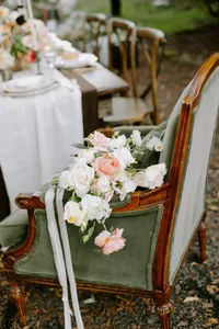 Bridal bouquet placed on vintage chair as part of garden wedding design