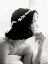 Black-and-white portrait of a bride wearing a delicate floral halo headpiece, glancing over her shoulder in a Santa Barbara wedding editorial by Yuliya Supin Design