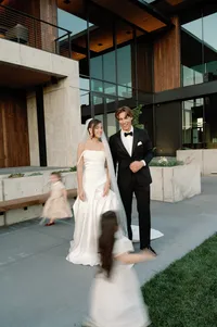 Couple enjoying watching flower girls running around with laugh and joy