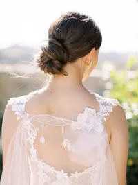 Bride from behind wearing embroidered gown and veil during vineyard wedding in Santa Ynez.