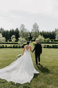 Bride and groom walking through garden during luxury private estate wedding in Vancouver, Washington.