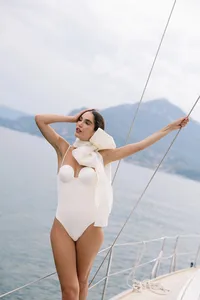 Model posing on sailboat in modern bridal fashion piece during Lake Como editorial