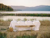 Wedding table setup in open field with lake view and organic styling