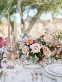 Wedding ceremony chairs and flowing silk aisle decor set against Sunstone Winery stone architecture.