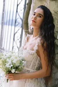 Bride in couture gown holding white and green bouquet at Hotel Villa Cipressi