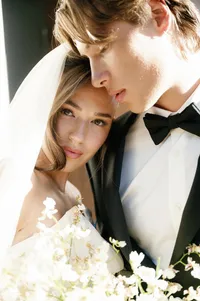 Close-up portrait of bride and groom sharing an intimate moment in vineyard light.