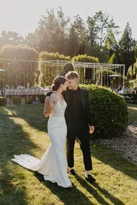 Bride and groom walking hand in hand through estate garden at luxury wedding in Vancouver, Washington.