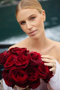 Bride holding a bouquet of deep red roses