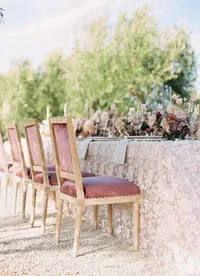 Wedding reception table with pink velvet chairs and florals at Sunstone Winery.