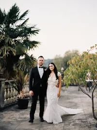 Bride and groom portrait on a balcony with palm trees at sunset during their romantic Lake Oswego Oregon winery wedding.