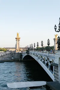 Architectural view of the Pont Alexandre III bridge and the Seine River in Paris.
