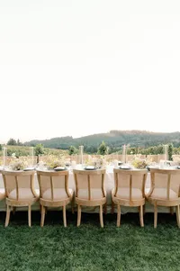 Luxury reception table styled beneath expansive Oregon sky with rolling vineyard hills in the distance.