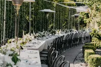Outdoor driveway reception with black chairs and string lights at a private estate wedding in Vancouver, Washington.