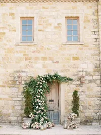 Outdoor ceremony setup with garden roses and vintage doors at Sunstone Winery in Santa Ynez Valley.