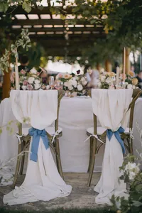 Head table setup with silk linens, ribbon-tied chairs, and an ivy-covered pergola creating a romantic reception setting at a Lake Oswego Oregon winery wedding.