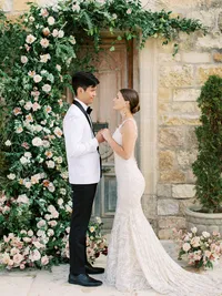 Bride and groom exchanging vows during outdoor ceremony at Sunstone Winery vineyard wedding in Santa Ynez Valley.