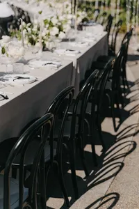 Outdoor reception with half arch structure, black chairs, and ivory velvet linens at private estate wedding in Vancouver, Washington.