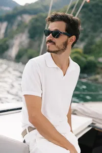 Groom aboard private sailboat during Lake Como wedding celebration