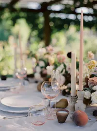 Close-up of wedding table styling with romantic garden florals, fruit accents, and elegant glassware during a Lake Oswego Oregon winery wedding reception.