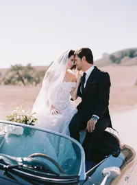 Bride and groom riding off in a vintage convertible, her veil catching the wind, from a Santa Barbara wedding editorial by Yuliya Supin Design