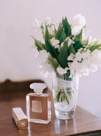 Chanel perfume and a glass of lily of the valley on the nightstand, a getting-ready detail from a Santa Barbara wedding editorial by Yuliya Supin Design