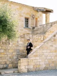 Groom walking across the stone courtyard toward ceremony at Sunstone Winery wedding.