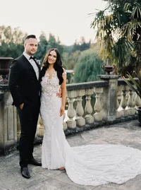 Bride and groom portrait on an Italian-style stone balcony overlooking the gardens during a romantic winery wedding in Lake Oswego, Oregon at sunset.